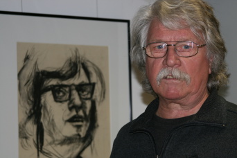Ein Mann rechts, links eine Zeichnung im schwarzen Rahmen.