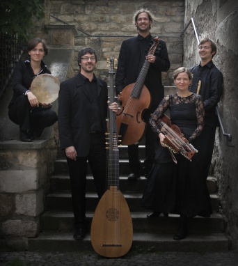 Fünf Personen mit Instrumenten auf einer Steintreppe.