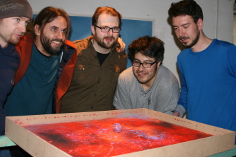Fünf Männer schauen auf ein Kunstwerk.