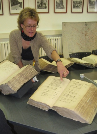 Eine Frau zeigt auf ein altes Buch.