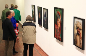 Besucher stehen vor Ausstellungsbildern.
