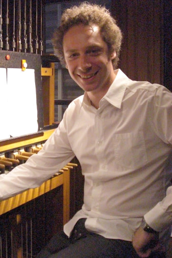 Junger Mann im weißen hemd an einem Instrument