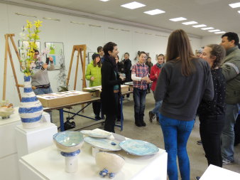 Jugendliche in einem Atelier, im Vordergrund Keramikarbeiten