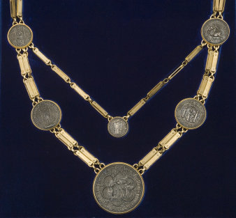 Zweigeteilte, goldene Kette mit sechs eingearbeiteten Münzen.