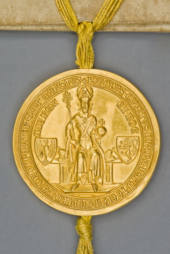 Mittelalterliches Urkundensiegel aus Metall mit der Abbildung des Kaisers und desses Wappen.