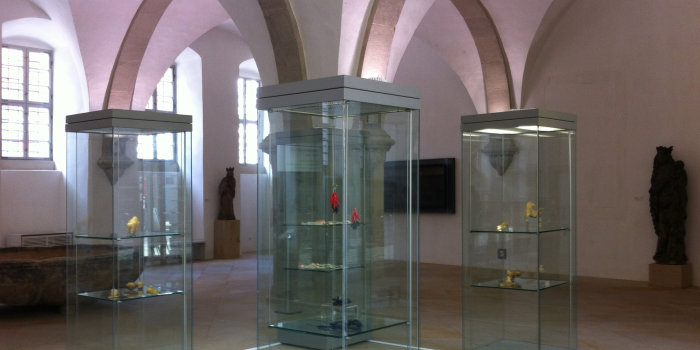 drei Glasvitrinen mit Kunstwerken im Foyer des Angermuseums