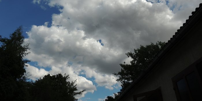 Blauer, wolkenverhangender Himmel.