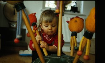 Kind spielt mit Spielzeugfiguren auf einem Stiel