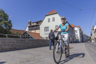 Frau fährt in der Stadt mit dem Rad.