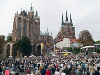 Zahlreiche Menschen vor der Kirchenkulisse Erfurts