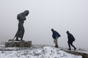 Zwei Pilger in winterlicher Landschaft auf dem Wege zu einer Pilger-Skulptur