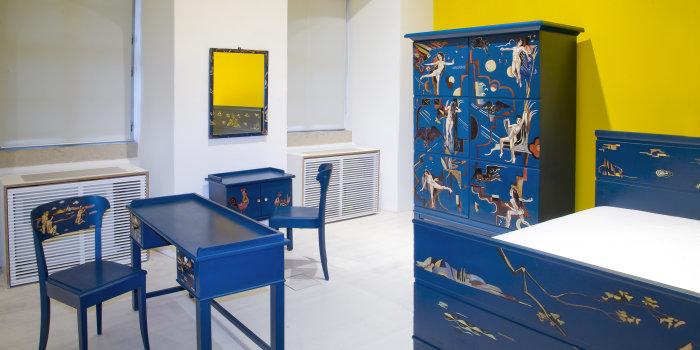 Foto: Achtteiliges, von Helmuth Macke gestaltetes Schlafzimmer-Ensemble © Stadtverwaltung Erfurt Blaue Schlafzimmermöbel mit Bemalung - ein Tisch, zwei Stühle, ein Kleiderschrank, ein Bett, eine große und eine kleine Kommode sowie ein Spiegel