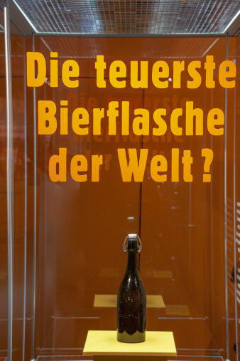Eine Bierflasche in einer Vitrine mit der Aufschrift "Teuerste Bierflasche der Welt?"