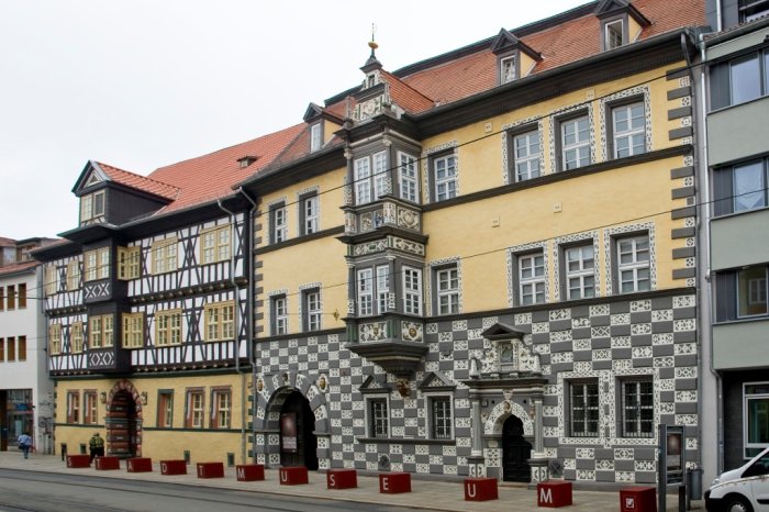 Stadtmuseum „Haus zum Stockfisch“ Sicht auf die reich verzierte Fassade eines Hauses und davorstehende rote Würfel, die das Wort Stadtmuseum ergeben