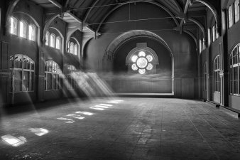 Schwarz-weiß Foto einer Halle, in die Licht einfällt