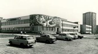 Schwarz-weiß Foto des Wandmosaiks mit Autos im Vordergrund