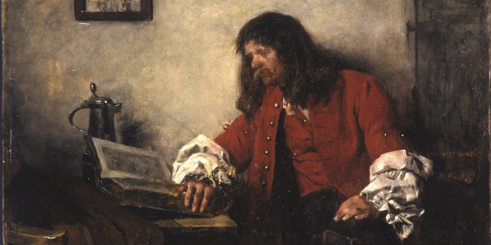 Mann in roter Robe liest ein Buch.