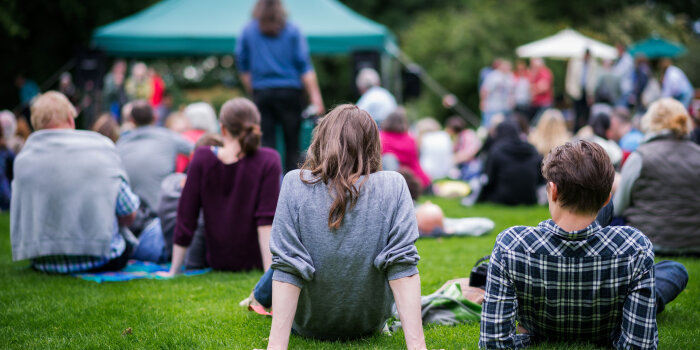 Mehrere Menschen sitzen auf einer freien Fläche