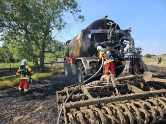 Der Brand einer landwirtschaftlichen Maschine wird von der Feuerwehr gelöscht.