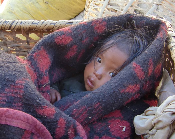 Nepal/Kind im Phu-Tal kleineres Kind in Decke gehüllt