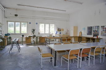 Werkbänke, Tische, viele Stühle, verschiedene Maschinen, lichter Raum