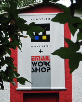Foto: Künstlerwerkstätten Außenansicht mit Banner Banner mit Schriftzug Künstlerwerkstätten und Email-Workshop