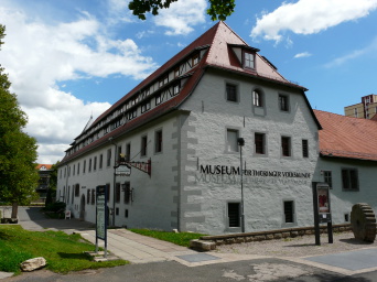 Ein historisches Gebäude mit Krüppelwalmdach, darauf der Schriftzug "Museum für Thüringer Volkskunde Erfurt".