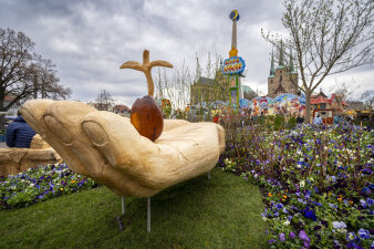 Domplatzbeet Holzskulptur große Hand mit einem Keimling in der Mitte des Beets