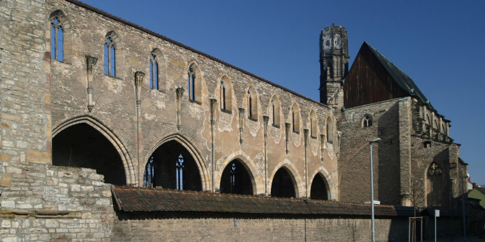 Großes Kirchenschiff ohne Dach, blauer Himmel.