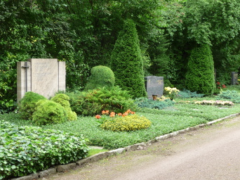 grüne gefasste Fläche mit Grabstein