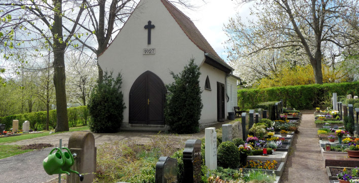 Weiße Kirche des Friedhofs in Marbach, daneben Gräber