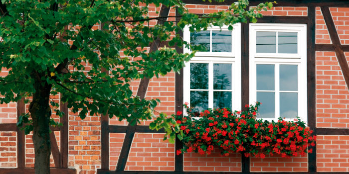 Fachwerkgebäude mit Blumenschmuck an Fensterkasten