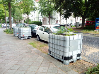 drei bepflanzte umgenutzte Wassercontainer