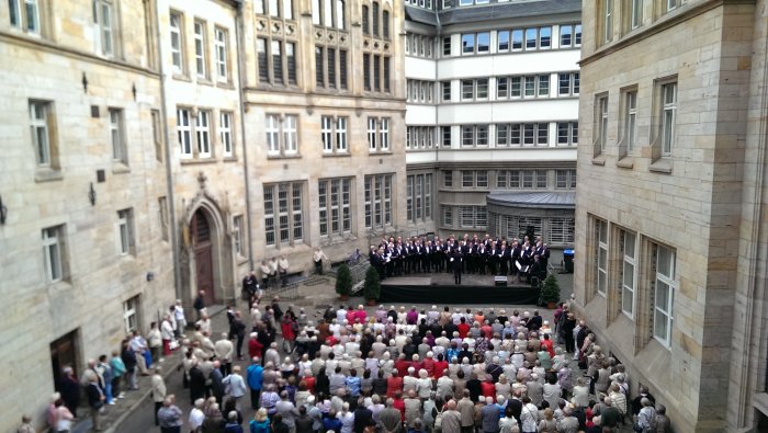 Chorkonzert im Rathausinnenhof Chor und Zuschauer in einem Gebäude umfassenden Hof