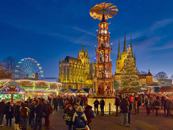 Erfurter Weihnachtsmarkt mit der Weihnachtspyramide und Fahrgeschäften im Vordergrund und dem Ensemble von Dom und St. Severi im Hintergrund