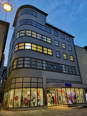 Foto: Bauhaus in Erfurt: Schellhornhaus © Stadtverwaltung Erfurt / H. Röder das „Schellhornhaus“ im Bauhausstil mit hell erleuchteten Fenstern in der Morgendämmerung