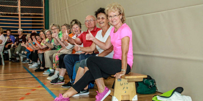 Foto: Senioren beim Sport © Stadtverwaltung Erfurt/Seniorenbeirat Ältere Menschen sitzen auf einer Bank in einer Sporthalle und heben ihre Daumen