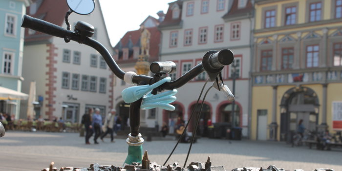 Foto: Fahrrad am Fischmarkt © Stadtverwaltung Erfurt Fahrradlenker mit Schloss vor dem Modell der Erfurter Altstadt am Fischmarkt