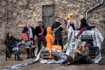 Foto: Ensemble Miet + © Miet+ die Künstler mit ihren Instrumenten vor alter Fassade mit verdorrtem Weinstock