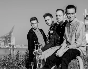 Schwarz-Weiß-Bild von vier junge Männer von denen einer eine Trompete in der Hand hält
