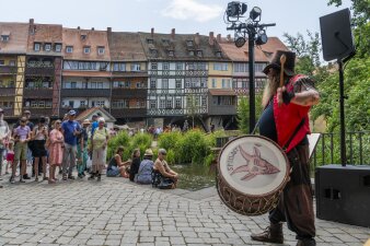 Mann mit einer Trommel, dem Passanten zuschauen 