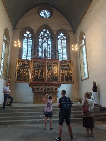 Merhere Poersonen in einer Kirche vor einen goldenen Altar