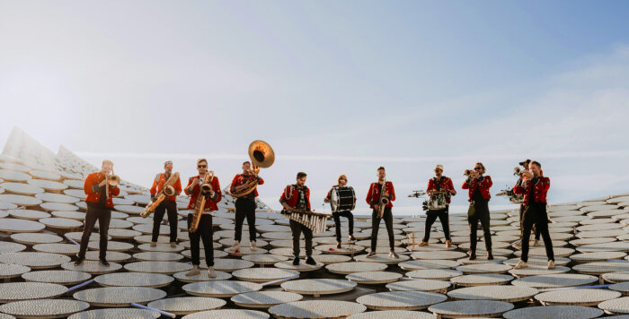 11 Musiker einer Blaskapelle vor grßem blauen Himmel