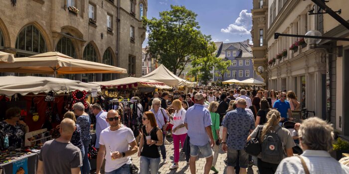 Viele Menschen, die an Verkaufsständen vorbeilaufen 