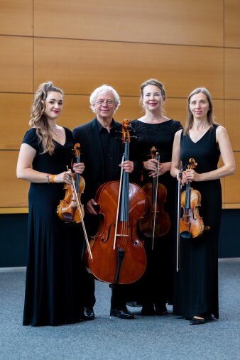 Foto: Streichquartett um Eugen Mantu © Eugen Mantu 4 Musiker mit ihren Instrumenten stehen vor einere Holzwand