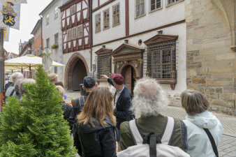 Mehrere Personen bei einer Führung vor einem Fachwerkhaus