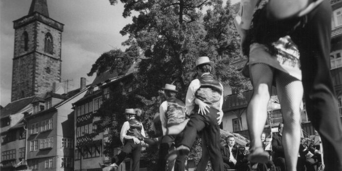 Im Vordergrund Ballettpaare und Orchestermusiker und im Hintergrund die Krämerbrücke