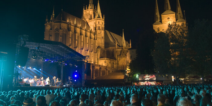 Die Bühne mit dem Sinfonieorchester und Pop-Band unterm Nachthimmel vor Dom und St. Severi