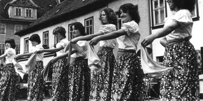 sieben Damen mit langen Röcken und weißen Blusen tanzen auf der Bühne Wenigemarkt