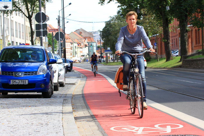 Radverkehr in Erfurt Radfahrerin befährt einen rot markierte Fahrspur, die Fahrrädern vorbehalten ist.